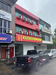 a black truck parked in front of a hotel at H Budget Hotel in Johor Bahru +2 photos