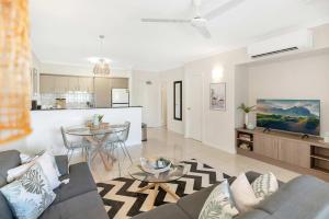 a living room with a couch and a table at Palm View- 9 Pools BBQ & Gym in Westcourt