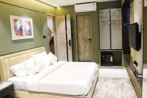 a bedroom with a white bed and a television at Hotel Comfort Inn in Pune +15 photos
