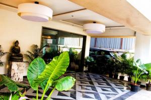 a lobby with a bunch of plants and lights at Hotel Comfort Inn in Pune