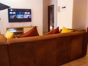a brown couch with colorful pillows in a living room at Alldays Sunset Lodge in Alldays