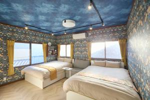 沼津Numazu Sparkle的一间卧室设有两张床和蓝色的天花板