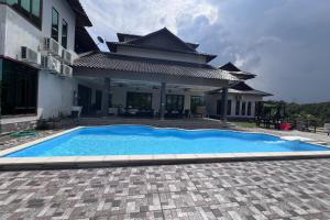 a swimming pool in front of a house at Nurbayu Chalet, Kemaman in Kuantan