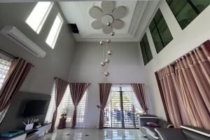 a living room with a ceiling fan and windows at Nurbayu Chalet, Kemaman in Kuantan