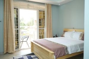 a bedroom with a bed and a sliding glass door at E- Residence in Gulu
