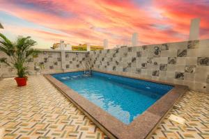 a swimming pool with a cloudy sky above it at Janz Marina Bay in Puducherry