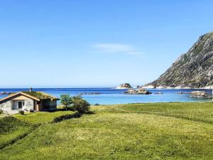 een huis op een grasheuvel naast de oceaan bij 8 person holiday home in Bremanger in Grotle