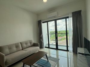 a living room with a couch and a large window at Gem Suites Kuching at 5 pax in Kuching