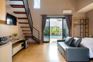 a living room with a couch and a staircase at Calma Jawon Villa Jogja in Piyungan