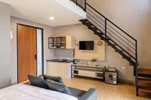a room with a bed and a kitchen with a staircase at Calma Jawon Villa Jogja in Piyungan