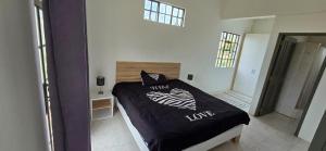 Un dormitorio con una cama con un edredón blanco y negro. en Maison de Vacances Pereybere, en Grand Baie