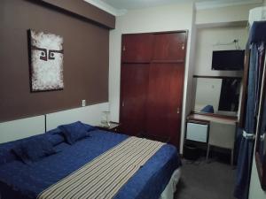 a bedroom with a bed with a blue comforter at Duplex Centro Salta in Salta