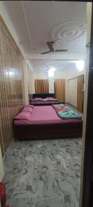 a bedroom with a large bed with purple sheets at Shri Raameshvaram vidya vila in Ayodhya
