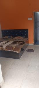 a bed in a bedroom with an orange wall at Shri Raameshvaram vidya vila in Ayodhya +5 photos