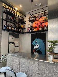 un bar avec une peinture de dinosaure sur le mur dans l'établissement homie青年旅舍, à Yantai