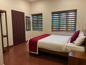 una camera da letto con un letto e due finestre di Janiro Tea Trees Villas a Vythiri