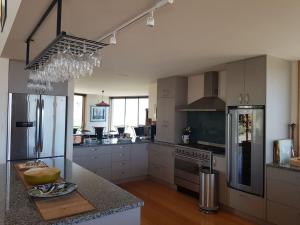 a large kitchen with white cabinets and stainless steel appliances at Marlborough Suite in an 6-bedroom luxury villa in Blenheim