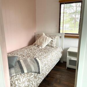 une petite chambre avec un lit et une fenêtre dans l'établissement Serendipity Cottage Farm Stay, à Jeremadra 34 autres photos