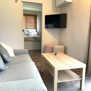 un salon avec un canapé et une table dans l'établissement Serendipity Cottage Farm Stay, à Jeremadra