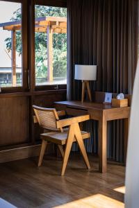 a wooden desk with a chair and a table with a lamp at Shankara Munduk Bali in Munduk