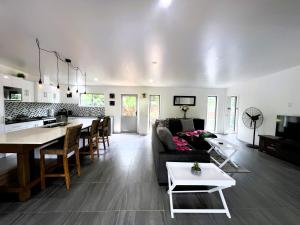 a living room and kitchen with a couch and a table at Ake Ake House in Rarotonga
