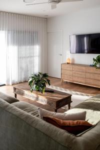 a living room with a couch and a tv at Valdora Eagles View - Sunshine Coast in Valdora