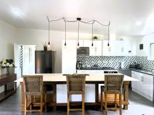 a kitchen with a large wooden table and chairs at Ake Ake House in Rarotonga