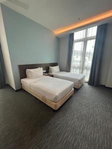 2 Betten in einem Hotelzimmer mit Fenstern in der Unterkunft Scott Hotel KL Sentral in Kuala Lumpur