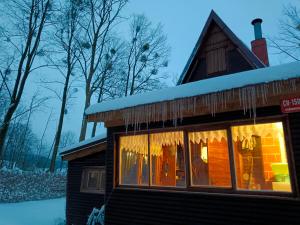 a cabin in the snow with icicles on the window at Chata Evička a Jiříček in Raškovice
