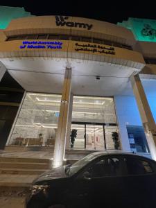 ein Auto, das nachts vor einem Gebäude parkt in der Unterkunft Sondos Al-Arbia in Riad