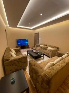 ein Wohnzimmer mit zwei Sofas und einem Flachbildfernseher in der Unterkunft Sondos Al-Arbia in Riad