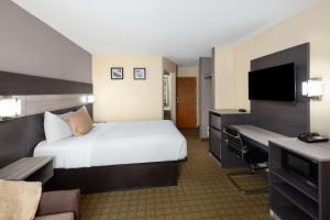 a hotel room with a bed and a desk at Travelodge by Wyndham Perry National Fairgrounds Area I-75 in Perry
