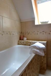ein Bad mit einer Badewanne und einem Fenster in der Unterkunft Brae House in Aberfeldy