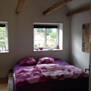 a bedroom with a bed with purple sheets and a window at Stor villa med privat have in Bredebro +7 photos