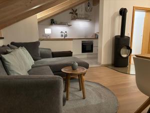 een woonkamer met een bank en een houtkachel bij Chesa Piz mit privater Sauna in Pfronten