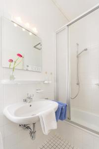 a white bathroom with a sink and a shower at Villa Waldfrieden - Ferienwohnungen und -Haus in Kochel +42 photos