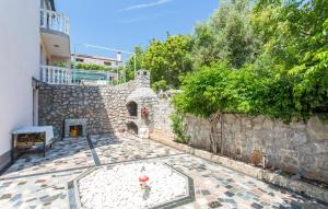 a stone building with a stone wall and a patio at Denjak Apartments in Kornić