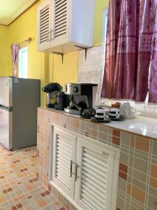 eine Küche mit Kühlschrank und Arbeitsplatte in der Unterkunft Baan Suan Thada Thai บ้านสวนธาดา ไทย in Wang Nam Yen