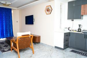 a kitchen with a table and a chair in a room at E-Residences in Gulu