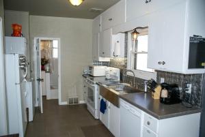 a kitchen with white cabinets and a sink at Home Away From Home home in Grand Junction