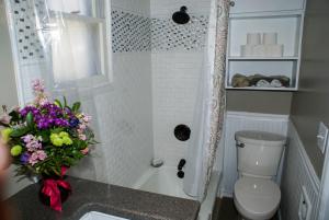 a bathroom with a toilet and a flower arrangement on a counter at Home Away From Home home in Grand Junction