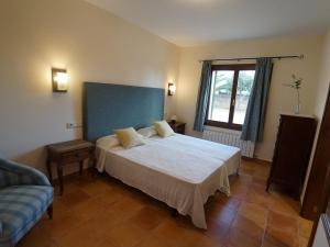 a bedroom with a large white bed and a couch at Finca Na Boneta in Santanyi +28 photos