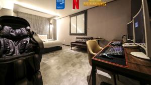 a room with a desk with a computer and a bed at Hotel Parfe in Cheonan
