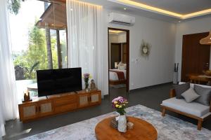 a living room with a flat screen tv on a table at Villa Suarga Des Anicca in Ubud