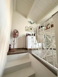 a white room with stairs and a fan at DOMMO ASULETTA in Bosa