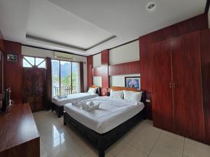 a hotel room with two beds and a balcony at Thavisouk Hotel, Vang Vieng in Vang Vieng