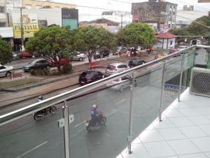 Castanhal的住宿－Estação Hotel，一个人在建筑物的阳台上骑着自行车