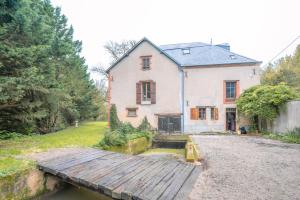 an old house with a wooden bridge in front of it at Moulin Bondon, group cottage - 14 beds in Graçay
