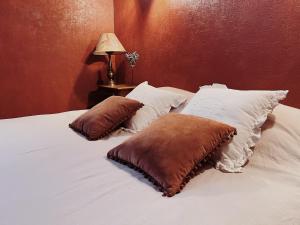 a bed with two pillows on top of it at La Cour des Grands in Revel