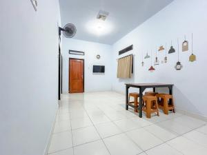 a room with a table and chairs in it at RedDoorz Syariah at Home Ampana Guest House Ampana Kota in Dondo